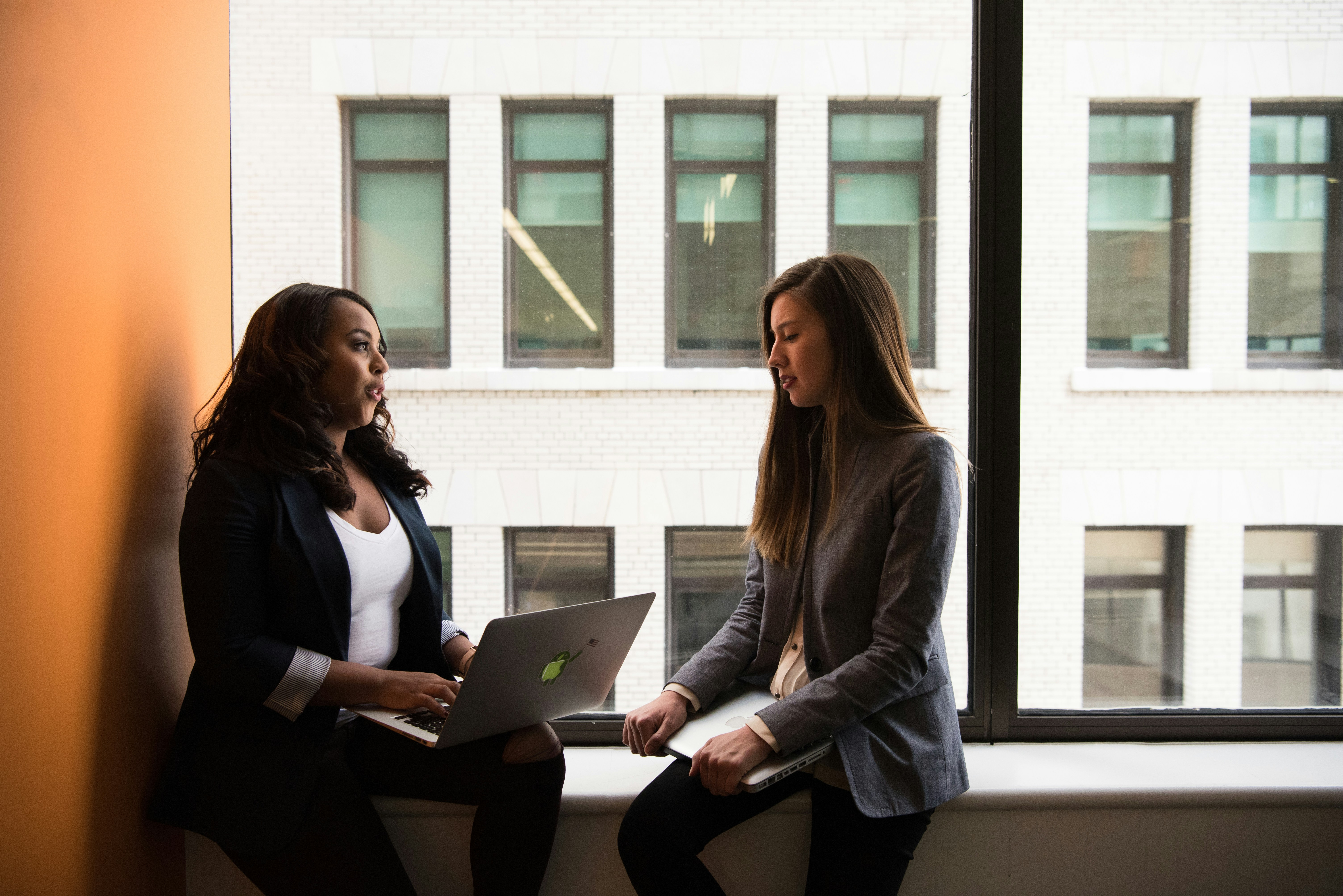Two professionals talking with a laptop